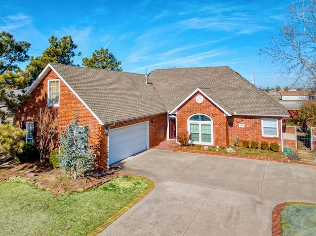 view of front of house featuring a garage, driveway, a shingled roof, and brick siding