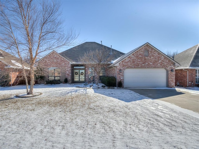 single story home featuring driveway, brick siding, and an attached garage