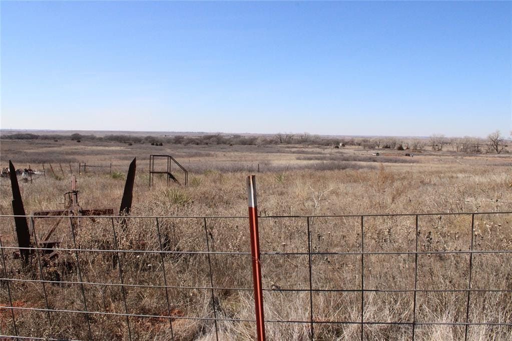 view of yard featuring fence and a rural view