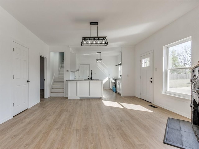 entryway with light wood-style flooring, visible vents, stairway, and baseboards