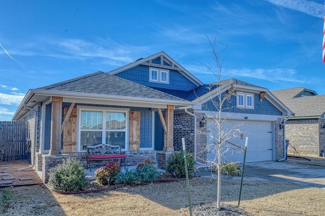 view of front of property with an attached garage, covered porch, a shingled roof, fence, and driveway