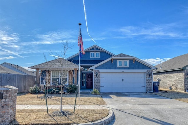 view of front facade with an attached garage, fence, concrete driveway, and brick siding