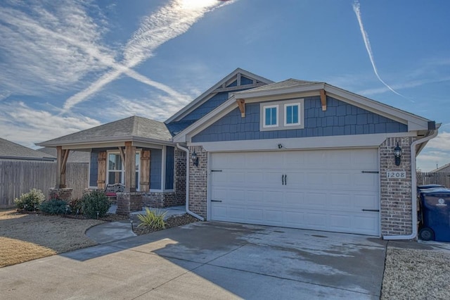 view of front of property with a porch, an attached garage, brick siding, fence, and concrete driveway