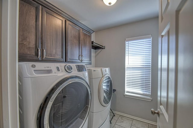 laundry room with washing machine and clothes dryer, cabinet space, and baseboards