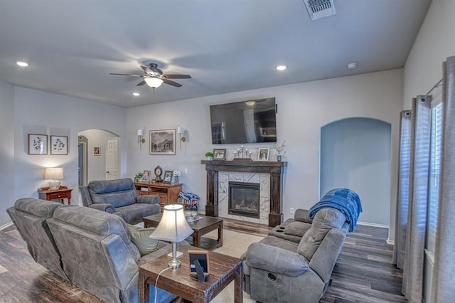 living room with arched walkways, dark wood-style flooring, a fireplace, recessed lighting, and visible vents