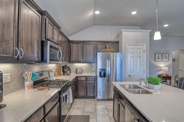 kitchen featuring hanging light fixtures, dark brown cabinetry, appliances with stainless steel finishes, and a sink