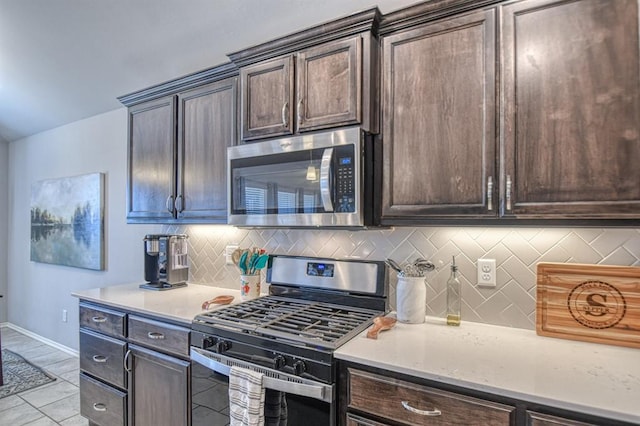 kitchen featuring stainless steel appliances, light countertops, decorative backsplash, and dark brown cabinets