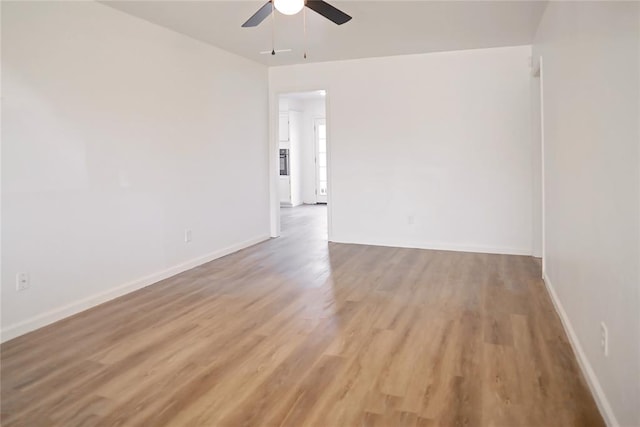 unfurnished room with light wood-type flooring and baseboards