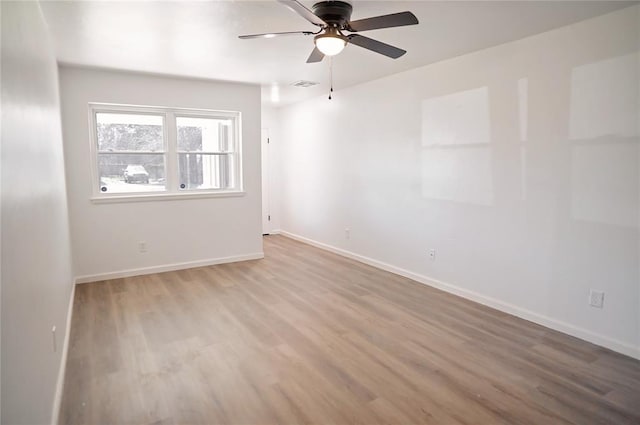 unfurnished room with visible vents, baseboards, ceiling fan, and wood finished floors