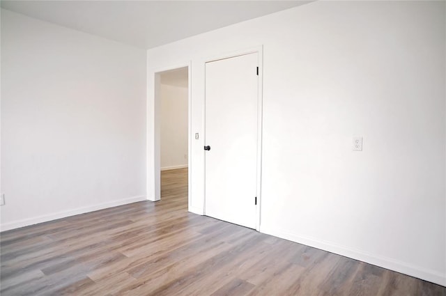 empty room featuring baseboards and wood finished floors