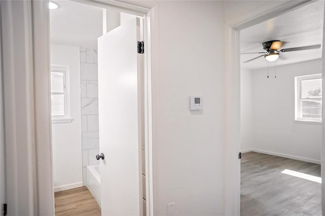 full bathroom featuring bathtub / shower combination, ceiling fan, baseboards, and wood finished floors