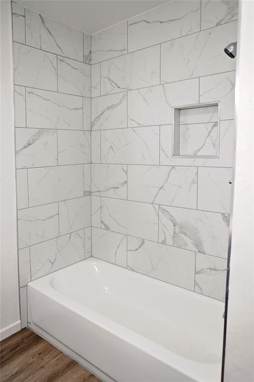 bathroom with bathtub / shower combination and wood finished floors