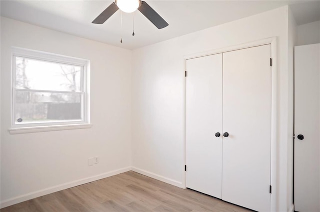 unfurnished bedroom with a ceiling fan, a closet, baseboards, and light wood finished floors