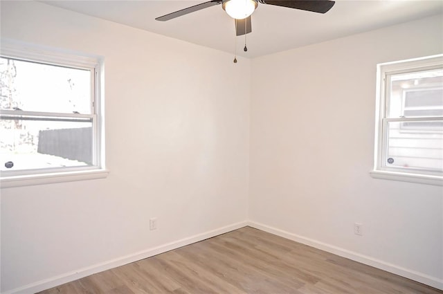 empty room featuring wood finished floors, a ceiling fan, and baseboards