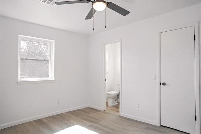 unfurnished bedroom with light wood finished floors, ceiling fan, baseboards, and connected bathroom