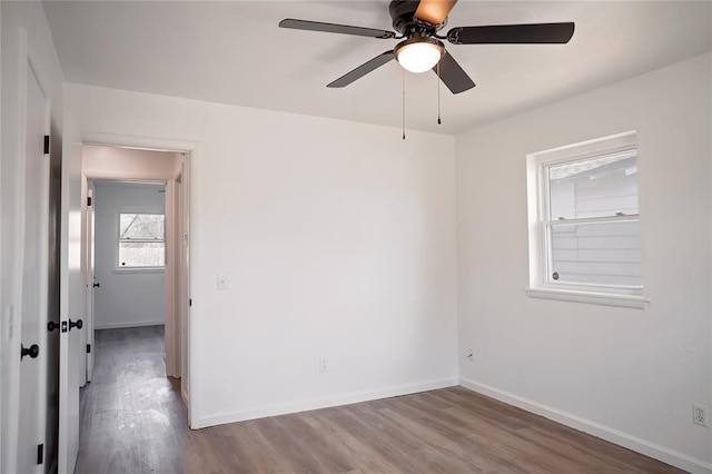 spare room with a ceiling fan, baseboards, and wood finished floors