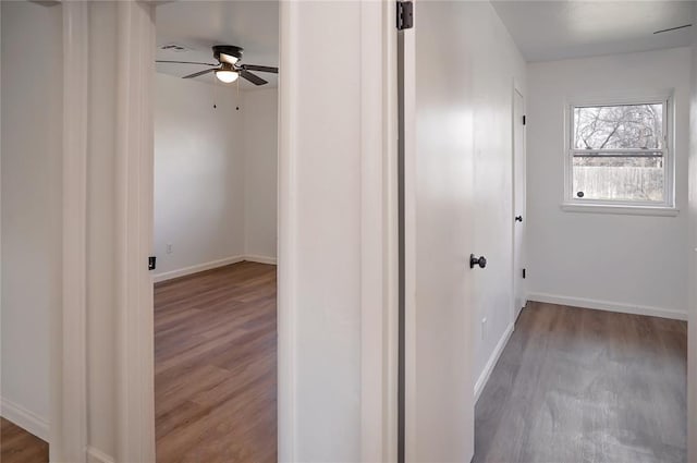 hall featuring baseboards and wood finished floors