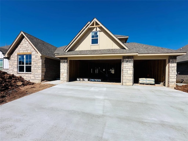 view of front of house featuring a garage, driveway, and roof with shingles