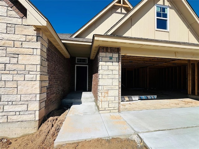 exterior space featuring a garage, brick siding, and roof with shingles