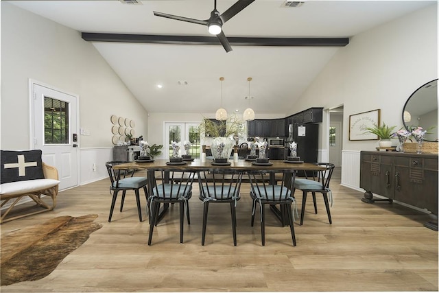 dining area featuring a wainscoted wall, beamed ceiling, and a healthy amount of sunlight