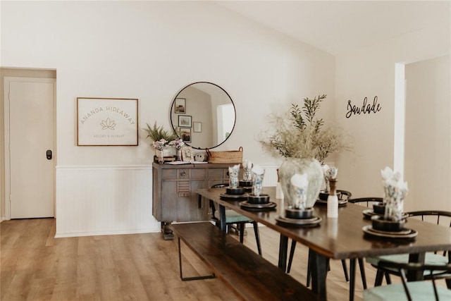 dining area with a wainscoted wall and wood finished floors