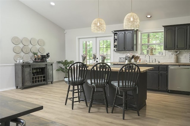 kitchen with dishwasher, plenty of natural light, a kitchen breakfast bar, and a center island