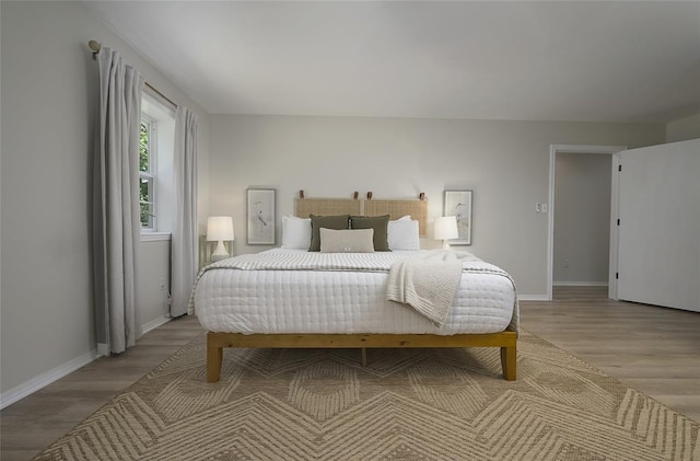 bedroom with wood finished floors and baseboards