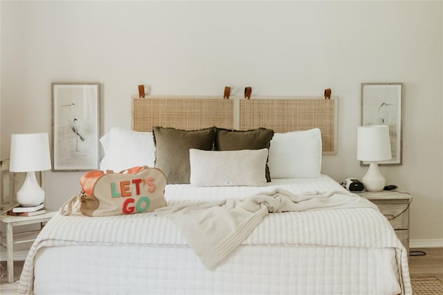 bedroom with baseboards and wood finished floors