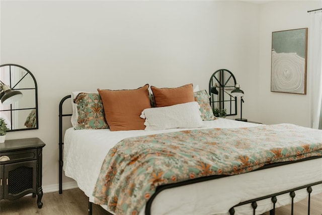 bedroom with baseboards and wood finished floors