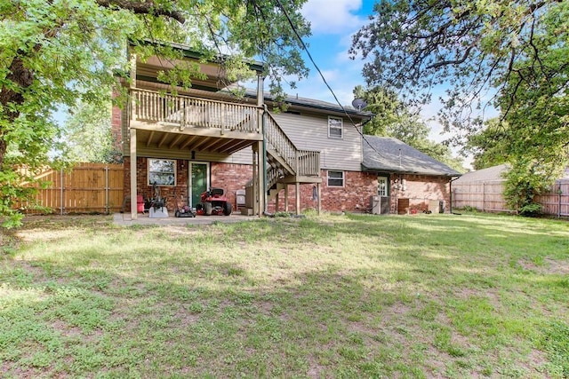 back of property featuring a fenced backyard, a lawn, and stairs