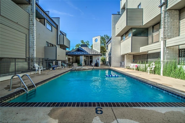 pool featuring fence and a patio