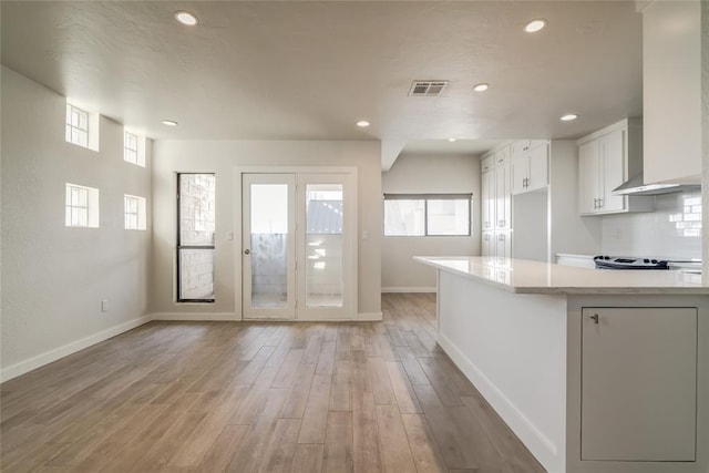 kitchen featuring light wood-style floors, baseboards, white cabinetry, and light countertops