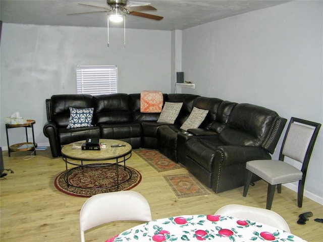 living area featuring ceiling fan, baseboards, and wood finished floors