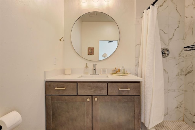 full bath featuring tiled shower and vanity