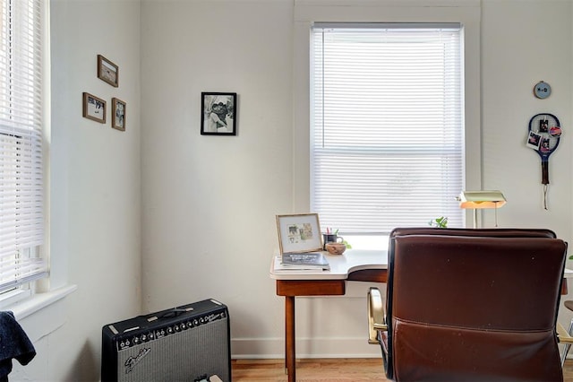 office area with light wood-style floors, plenty of natural light, and baseboards