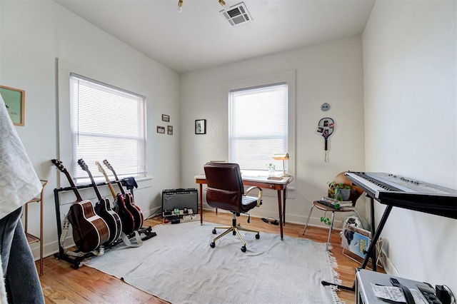 office featuring wood finished floors, visible vents, and baseboards