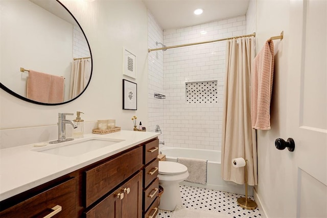 bathroom featuring toilet, shower / bath combo with shower curtain, and vanity