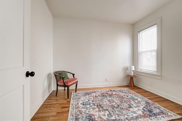 living area featuring baseboards and wood finished floors