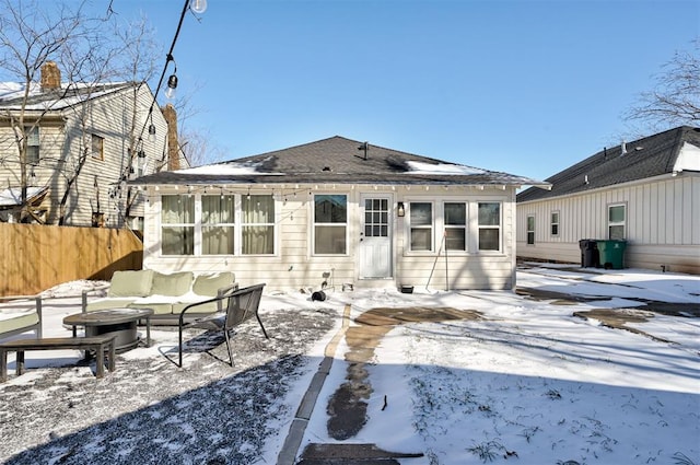 snow covered house featuring fence