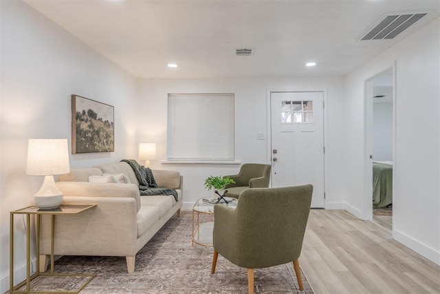 living area featuring light wood-style flooring, visible vents, baseboards, and recessed lighting