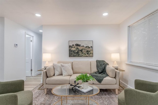 living area featuring baseboards, light wood finished floors, and recessed lighting