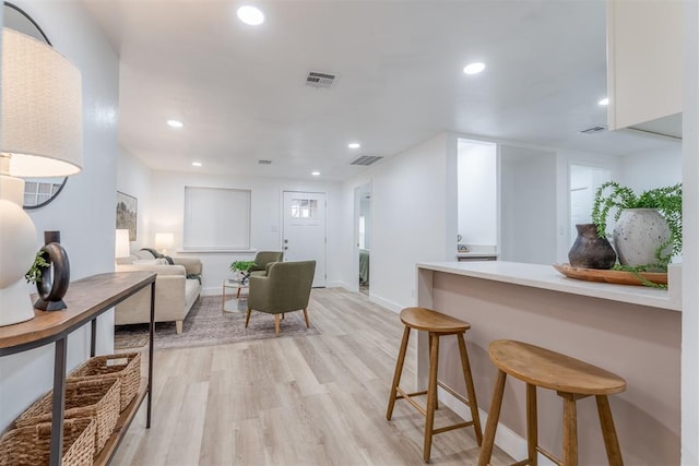 interior space with light wood-style flooring, recessed lighting, visible vents, white cabinets, and light countertops