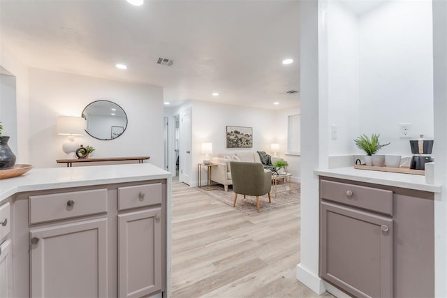 kitchen with light wood-style flooring, open floor plan, light countertops, and gray cabinetry