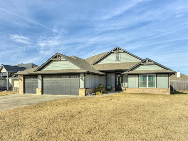 craftsman-style home featuring driveway, brick siding, roof with shingles, an attached garage, and a front yard