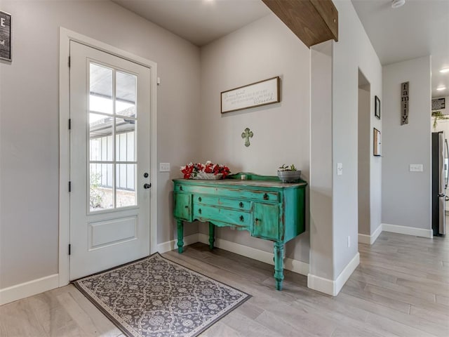 entryway with visible vents, baseboards, and wood finished floors