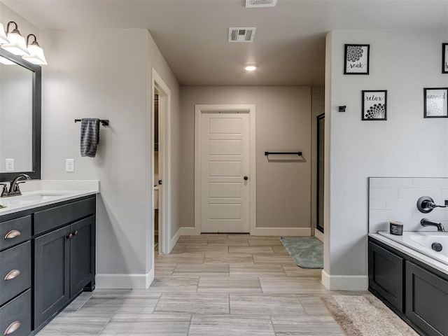 bathroom featuring a garden tub, a stall shower, vanity, and visible vents