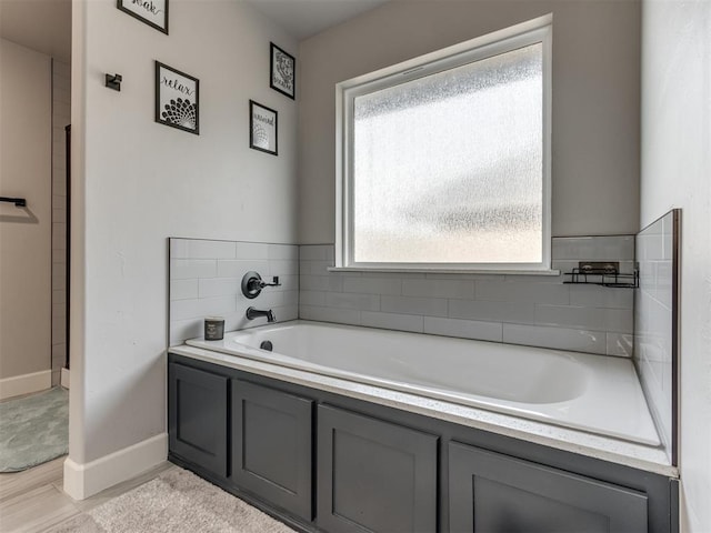 full bathroom featuring a garden tub and baseboards