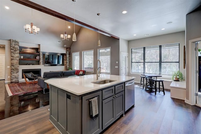 kitchen featuring pendant lighting, light countertops, gray cabinetry, a sink, and dishwasher