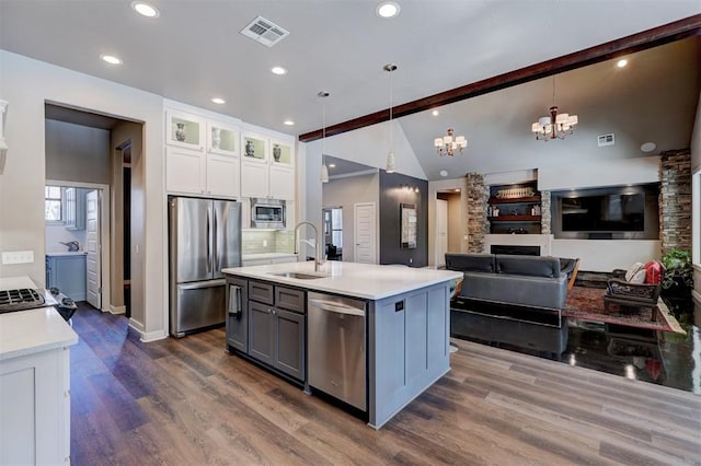 kitchen with white cabinets, glass insert cabinets, stainless steel appliances, light countertops, and a sink