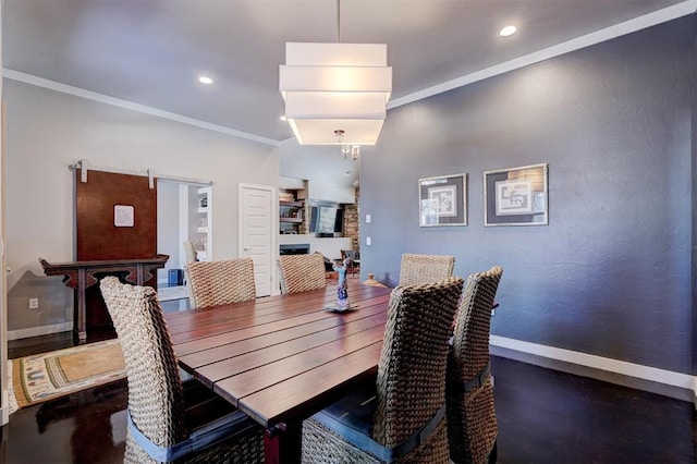 dining space with recessed lighting, crown molding, baseboards, and a barn door